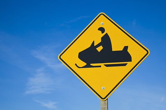 Careful! Snowmobiles! a sign on a pole