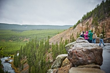 a man standing in front of a large rock