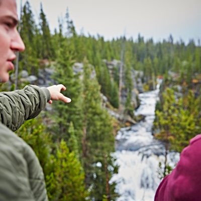 a man standing next to a forest