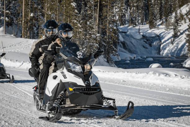 a group of people riding skis across snow covered ground