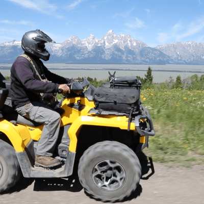 a person riding a motorcycle down a dirt road