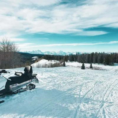 a person riding a snowboard down a snow covered slope
