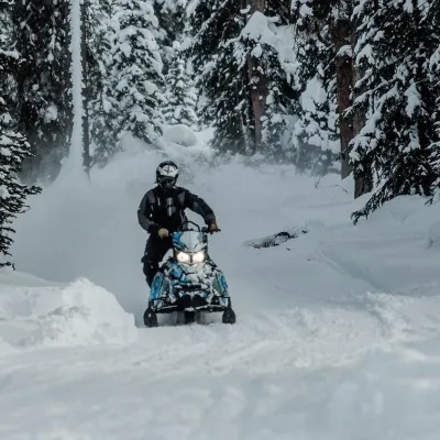 a man riding a snowboard down a snow covered slope