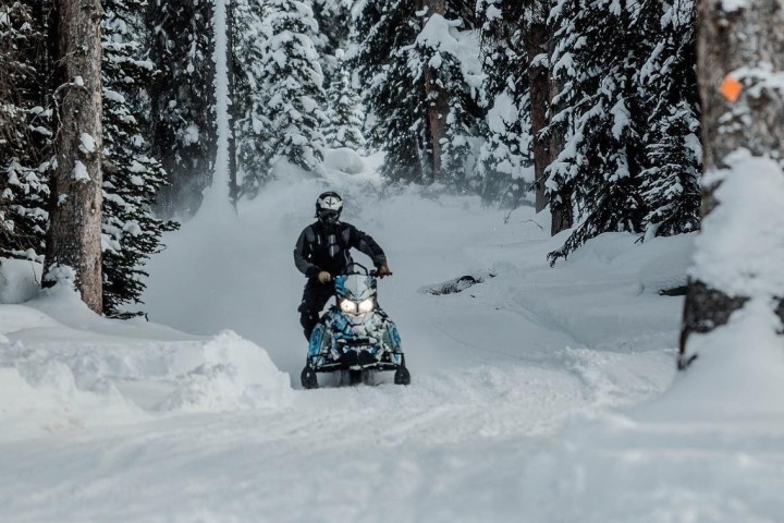 a man riding a snowboard down a snow covered slope