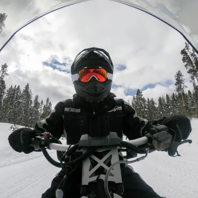 a person sitting on top of a snow covered slope