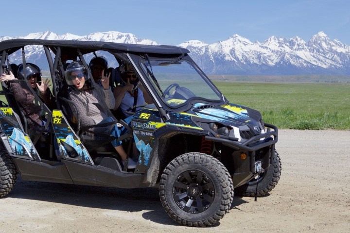 a man riding a motorcycle down a dirt road