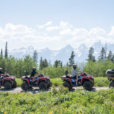 a group of people sitting on a motorcycle in a field