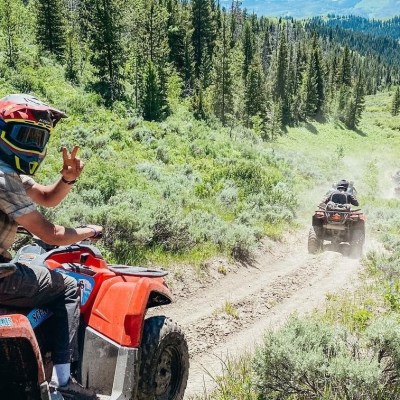 a man riding a motorcycle down a dirt road