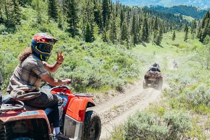 a man riding a motorcycle down a dirt road