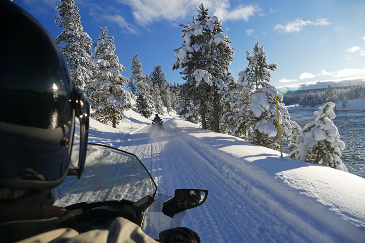 a man riding a snowboard down a snow covered slope