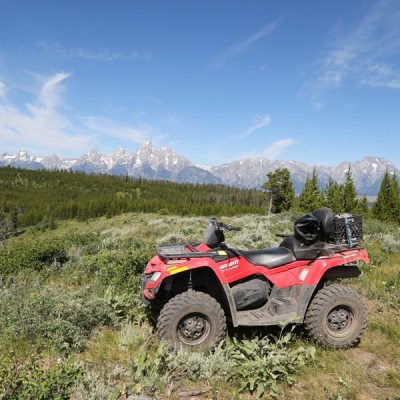 a truck is parked on the side of a dirt field