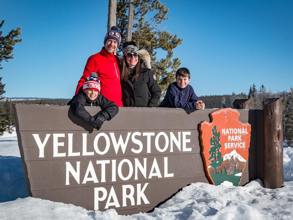 a person standing on a snow board in front of a sign