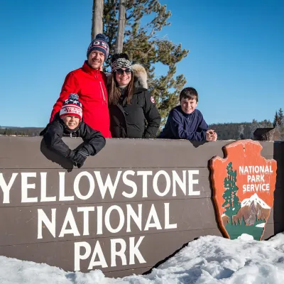a person standing on a snow board in front of a sign