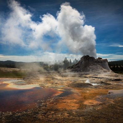 a group of clouds in the dirt with a mountain in the background