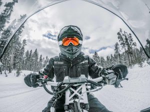 a person sitting on top of a snow covered slope